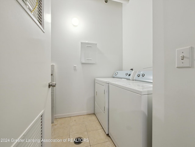 laundry room with washer and dryer and light tile patterned floors