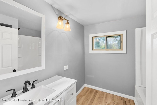 bathroom with hardwood / wood-style floors, vanity, and shower / bath combination