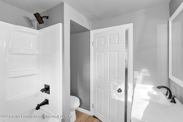 bathroom featuring toilet, a shower, wood-type flooring, and sink