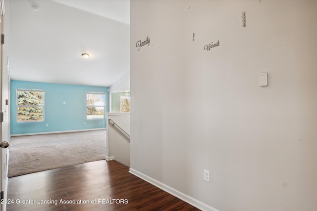 hall with dark hardwood / wood-style flooring and lofted ceiling