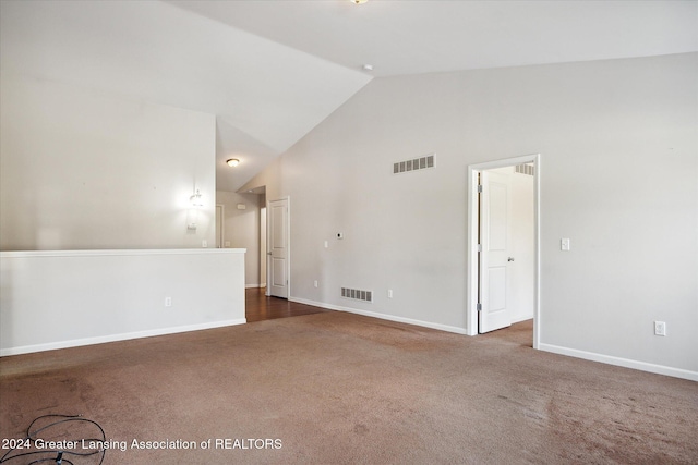 unfurnished room featuring dark carpet and vaulted ceiling