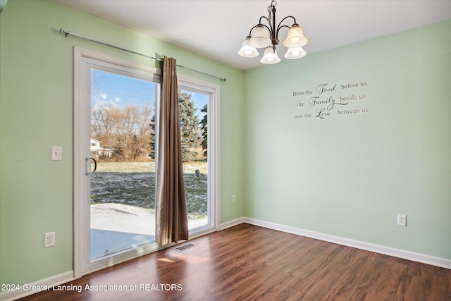 unfurnished dining area with hardwood / wood-style floors and a notable chandelier