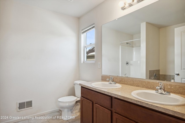 bathroom with a shower, tile patterned flooring, vanity, and toilet