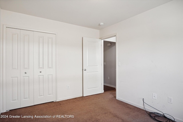 unfurnished bedroom featuring carpet floors and a closet