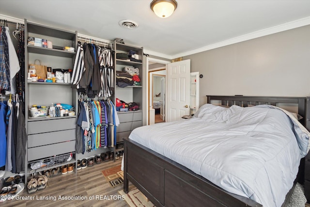 bedroom with hardwood / wood-style flooring and crown molding