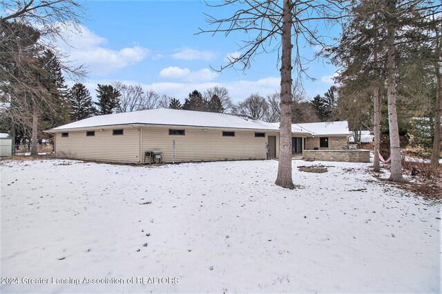 view of snow covered rear of property