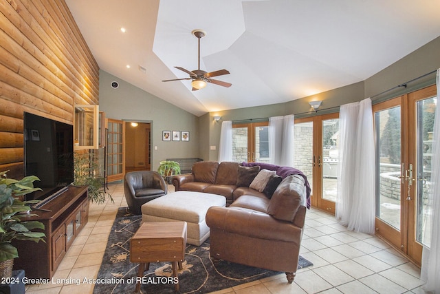 tiled living room with ceiling fan, vaulted ceiling, rustic walls, and french doors