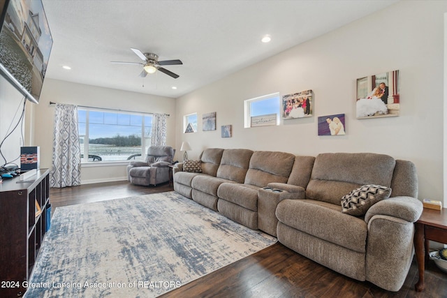 living room with ceiling fan and dark wood-type flooring