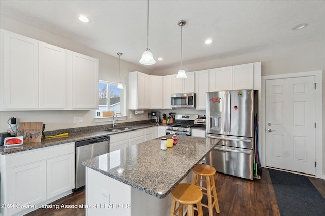 kitchen featuring pendant lighting, white cabinets, sink, appliances with stainless steel finishes, and a kitchen island