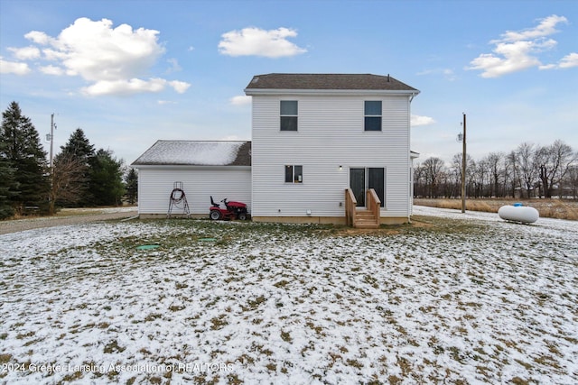 view of snow covered back of property