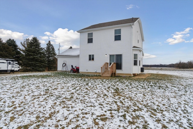 snow covered house featuring cooling unit