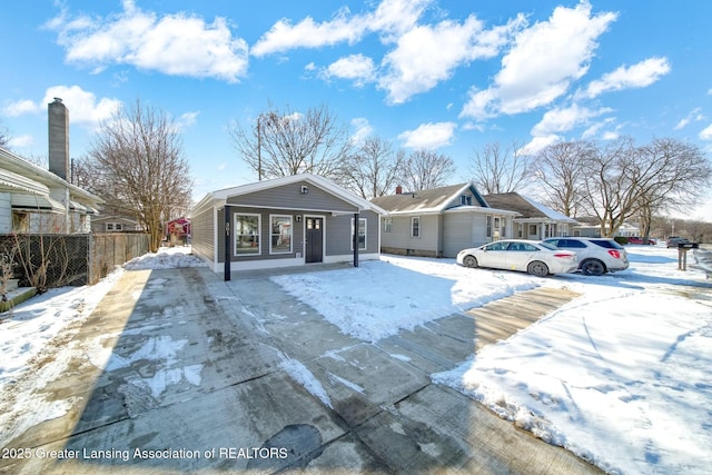 bungalow-style home with fence and driveway