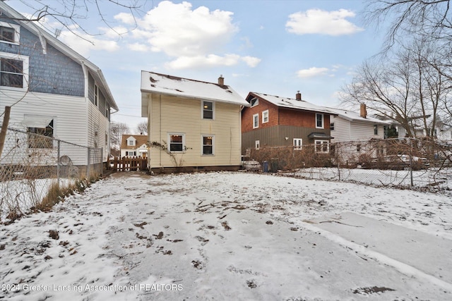 view of snow covered rear of property