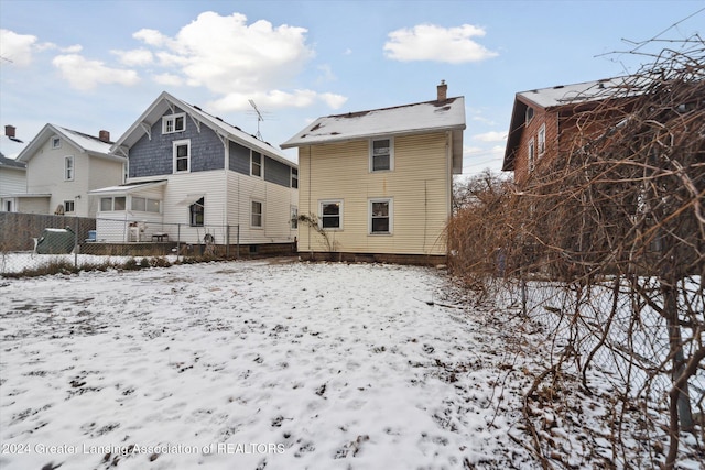 view of snow covered rear of property