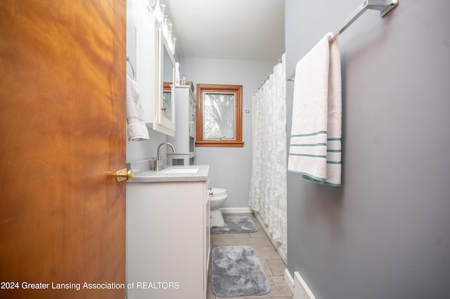 bathroom featuring tile patterned flooring, vanity, and toilet