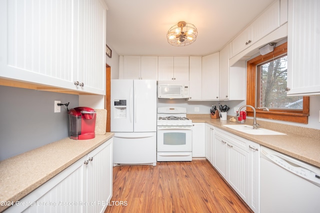 kitchen featuring white cabinetry, sink, white appliances, and light hardwood / wood-style flooring