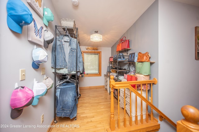 walk in closet with light hardwood / wood-style flooring and lofted ceiling