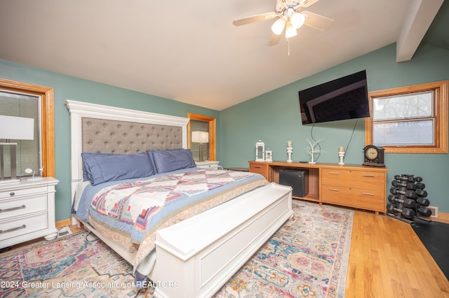 bedroom featuring vaulted ceiling with beams, ceiling fan, and light hardwood / wood-style flooring