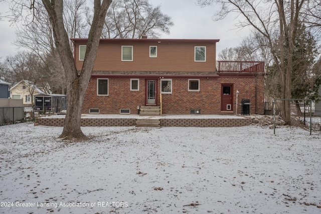 view of snow covered rear of property