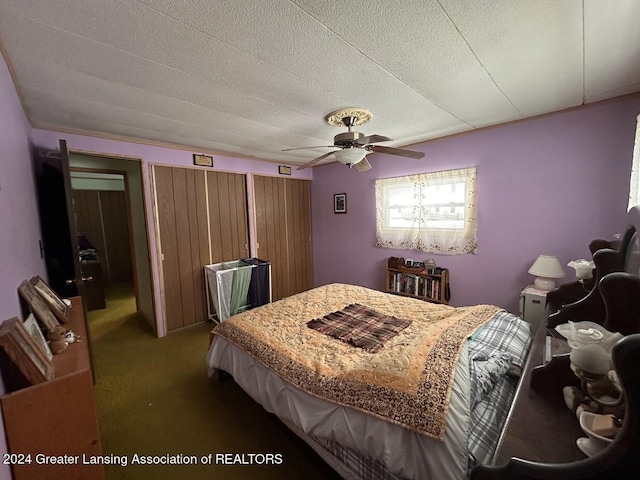 carpeted bedroom with ceiling fan and a textured ceiling