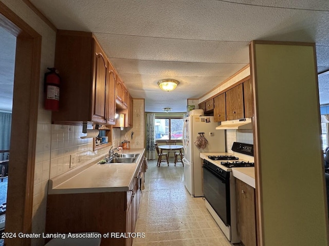 kitchen with white appliances, sink, and tasteful backsplash