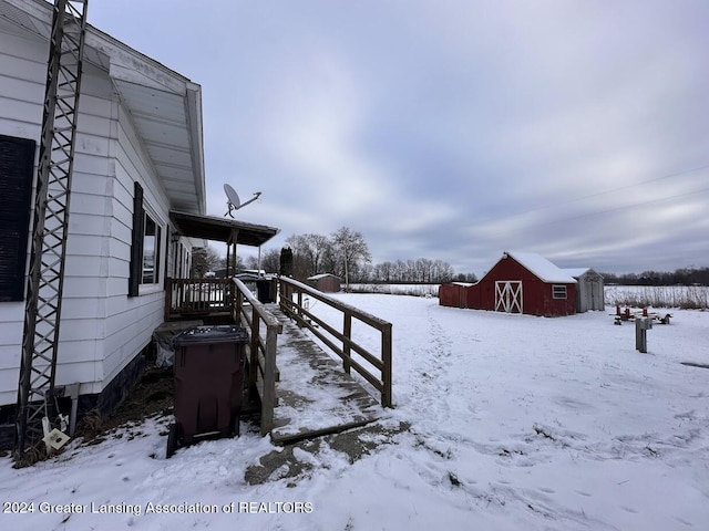 yard layered in snow with an outdoor structure