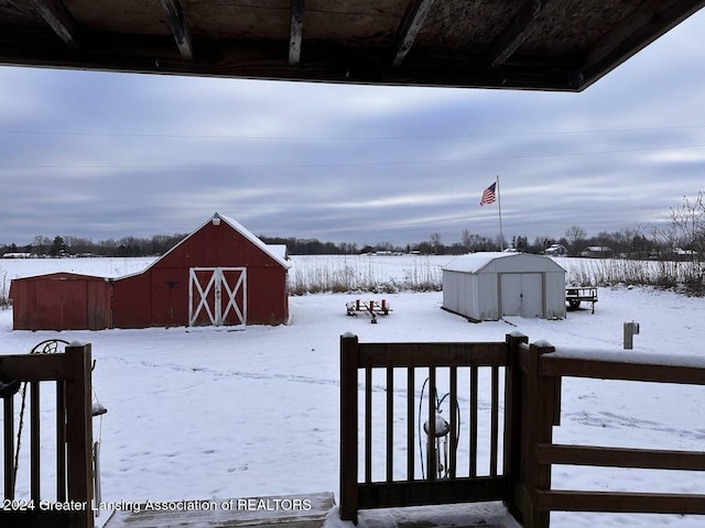 snowy yard featuring an outbuilding