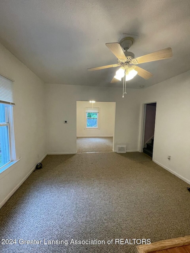 spare room featuring ceiling fan, carpet floors, and a textured ceiling