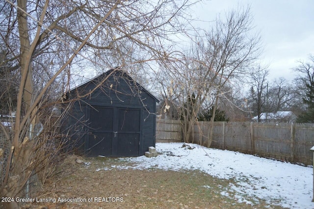 yard covered in snow with a storage shed