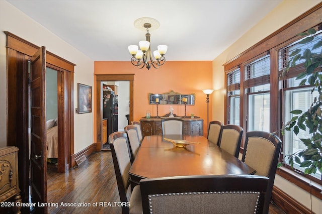 dining area with a notable chandelier and dark hardwood / wood-style flooring