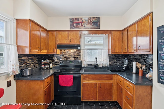 kitchen with decorative backsplash, sink, and black electric range