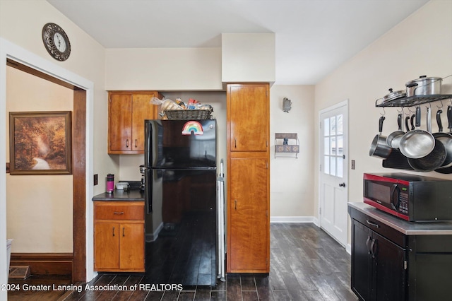 kitchen featuring black fridge and dark wood-type flooring