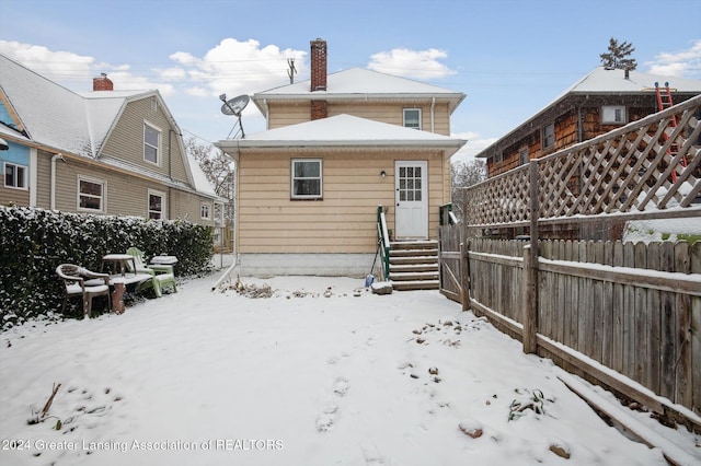 view of snow covered rear of property