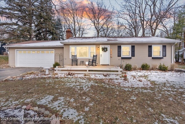 ranch-style home with covered porch and a garage