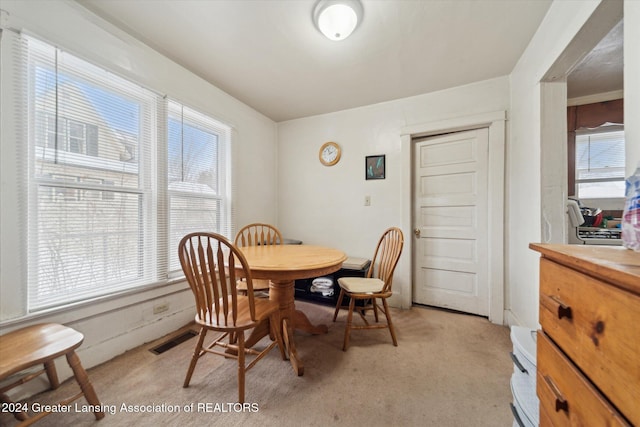 carpeted dining area with a healthy amount of sunlight