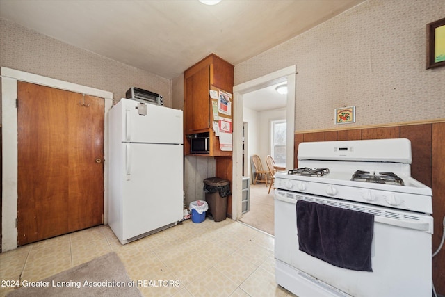 kitchen with white appliances and wood walls