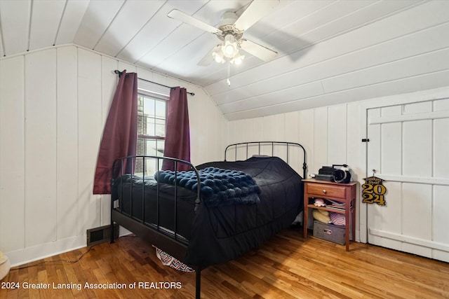 bedroom with ceiling fan, vaulted ceiling, and hardwood / wood-style flooring