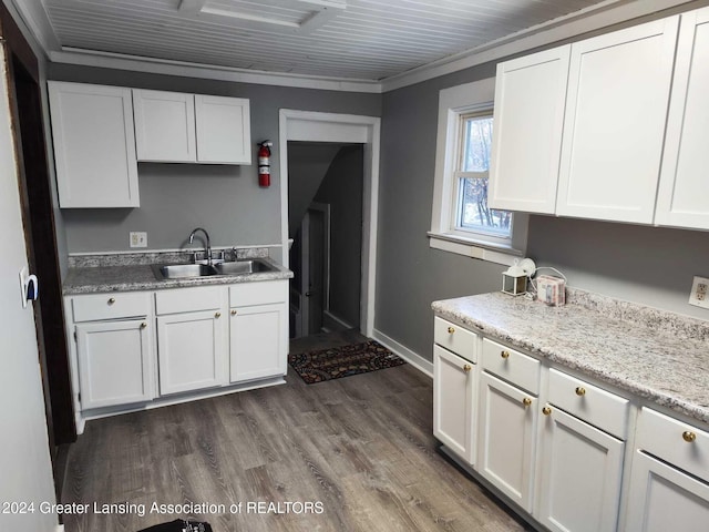 kitchen featuring dark wood-type flooring, sink, ornamental molding, light stone counters, and white cabinetry