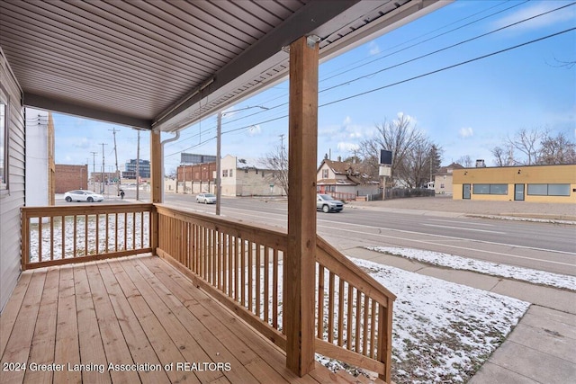 snow covered deck featuring covered porch