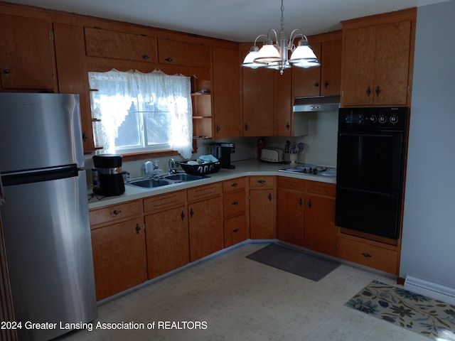 kitchen featuring stainless steel refrigerator, sink, white gas stovetop, a notable chandelier, and decorative light fixtures