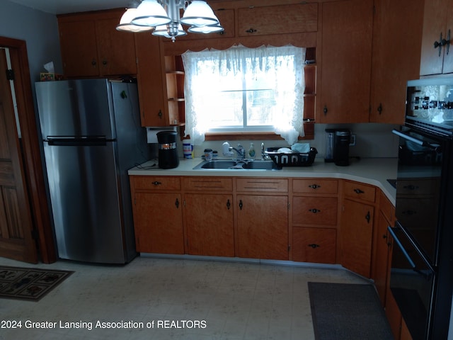 kitchen with sink, an inviting chandelier, double oven, stainless steel fridge, and pendant lighting