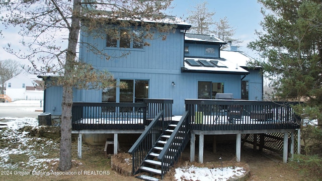 snow covered house featuring a wooden deck