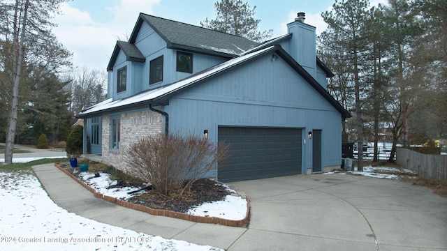 snow covered property featuring a garage