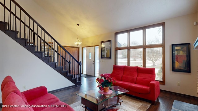 living room with dark hardwood / wood-style floors, vaulted ceiling, and a notable chandelier