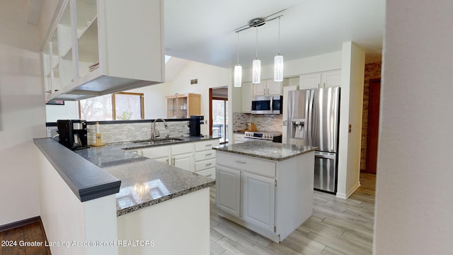 kitchen featuring appliances with stainless steel finishes, kitchen peninsula, sink, and white cabinets