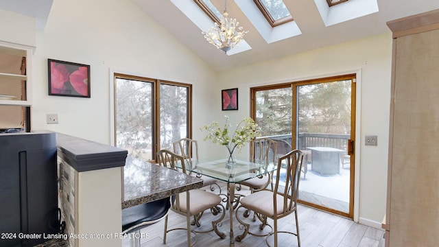 dining room with high vaulted ceiling, light hardwood / wood-style floors, and a notable chandelier