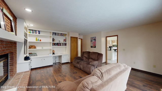 living room with a fireplace, dark hardwood / wood-style floors, and built in desk