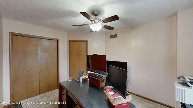 home office with a textured ceiling, light colored carpet, and ceiling fan