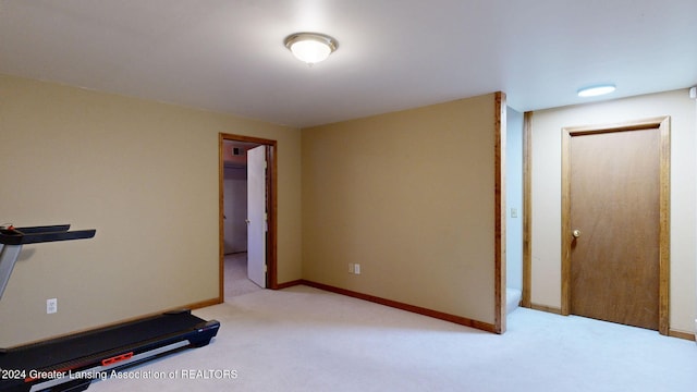 exercise room featuring light carpet