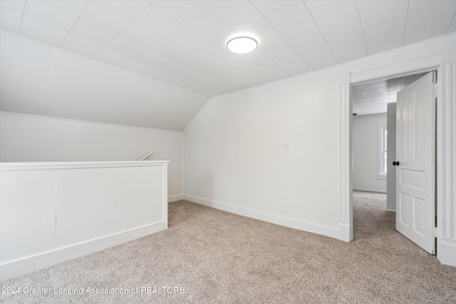 bonus room featuring light colored carpet and vaulted ceiling